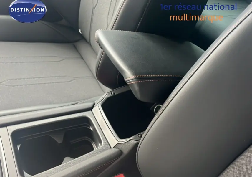 Détail de l'intérieur montrant l'accoudoir central ouvert et les sièges en tissu noir du CUPRA Formentor 2026.