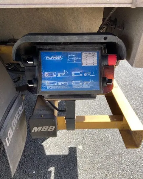 Gros plan sur la commande bleue du hayon Palfinger sous le châssis jaune du Ford Transit Chassis Cabine T350 2015.