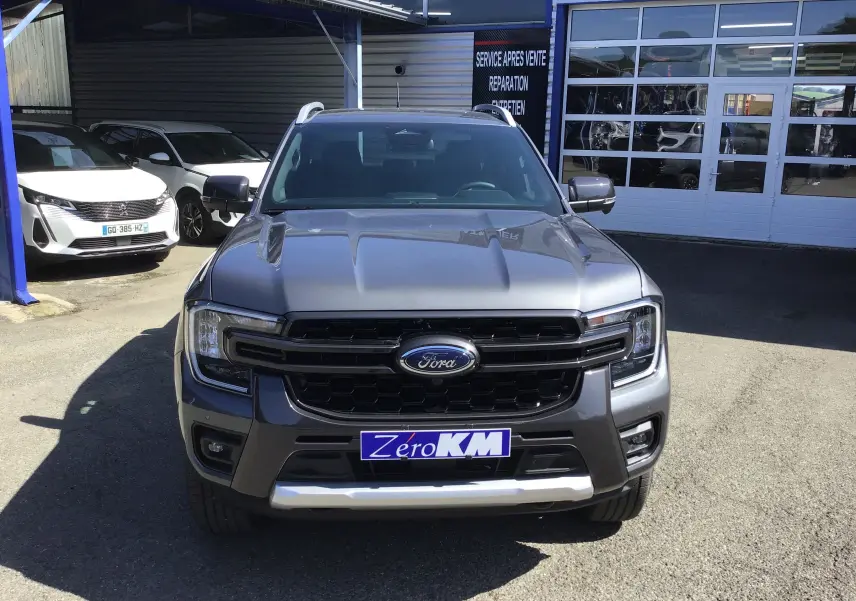 Vue frontale d'un Ford Ranger Double Cabine gris carbone 2025 avec calandre noire et plaque Zero KM visible.