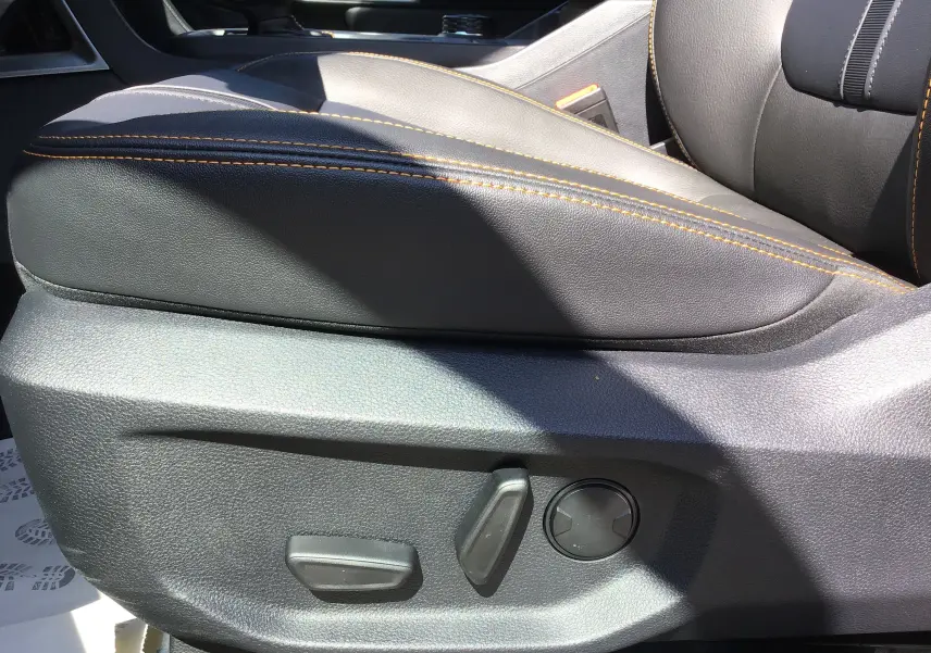 Gros plan sur le siège conducteur en cuir noir avec surpiqûres orange du Ford Ranger Wildtrak 2025 côté gauche.