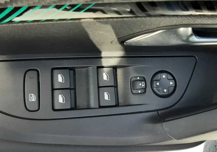 Panneau de commandes des vitres et rétroviseurs côté conducteur d'un Peugeot 2008 gris Artense 2022.