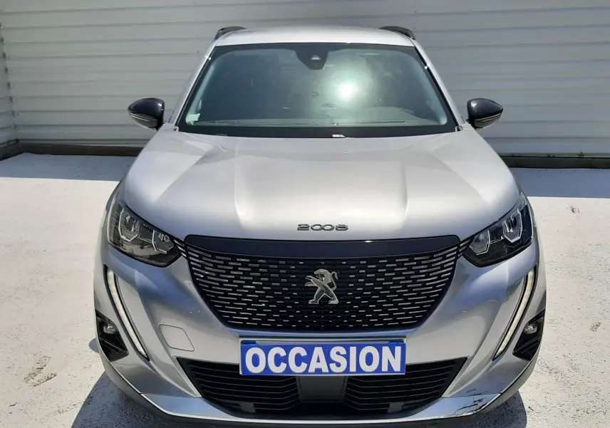 Vue avant d'un Peugeot 2008 gris Artense avec calandre noire et plaque "OCCASION" visible en extérieur.