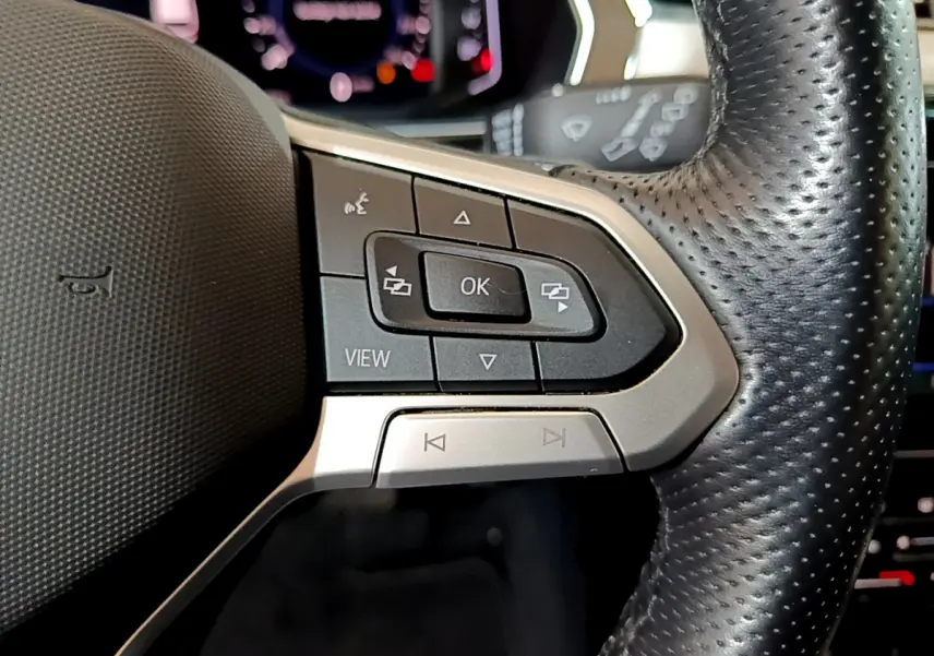 Gros plan sur les commandes du volant en cuir noir de la Volkswagen Passat hybride rechargeable 2022, côté gauche.