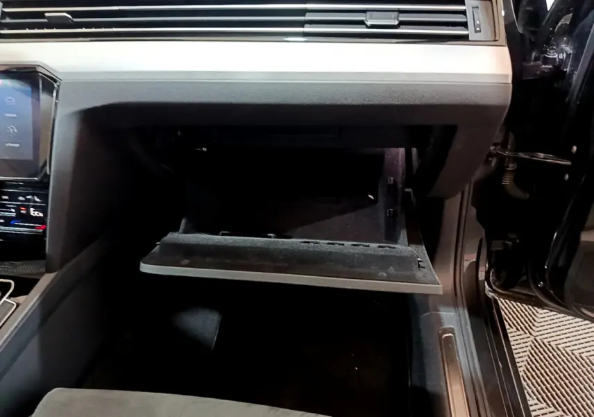 Gros plan sur la boîte à gants ouverte côté passager de la Volkswagen Passat GTE gris foncé 2022.