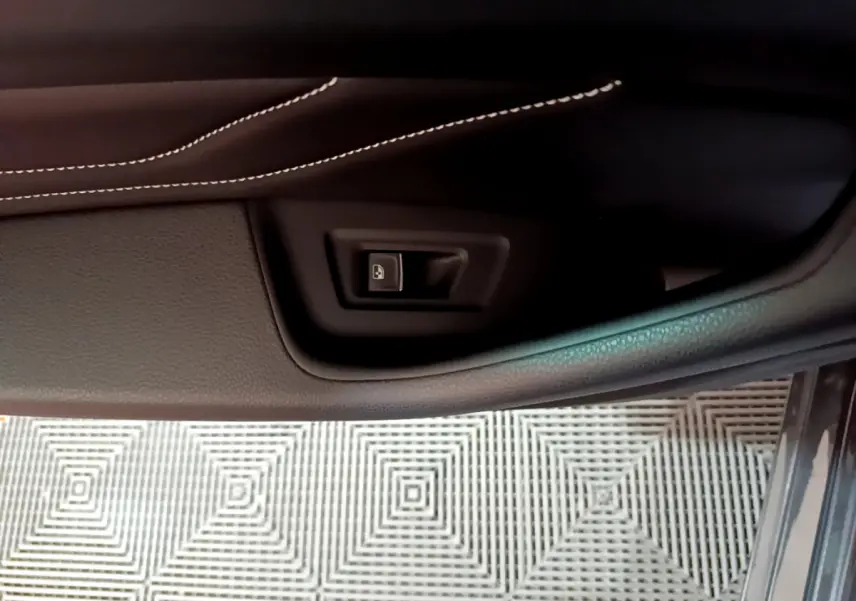 Détail de la commande de verrouillage de porte sur la garniture intérieure côté conducteur d'une Volkswagen Passat gris foncé 2022.