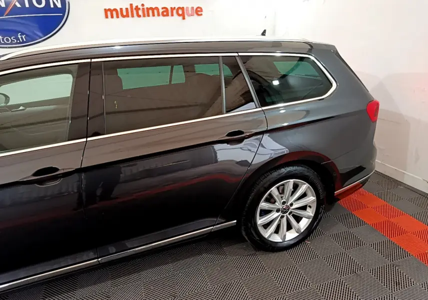 Vue latérale droite d'un break Volkswagen Passat gris foncé avec jantes alliage et vitres teintées.