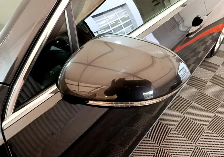 Rétroviseur côté gauche gris foncé de la Volkswagen Passat hybride rechargeable 2022 avec clignotant intégré.