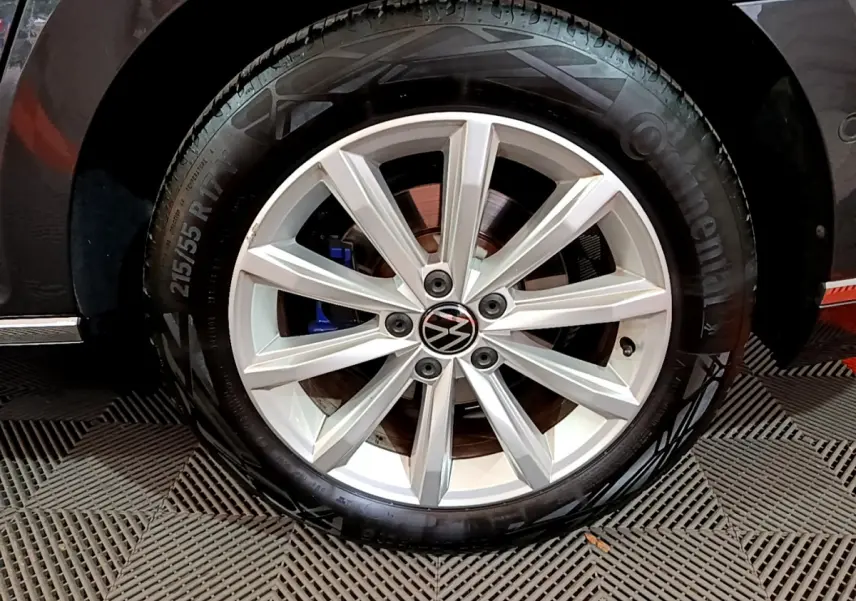 Gros plan sur la roue avant droite d'une Volkswagen Passat GTE gris foncé, jante alliage à 10 branches et frein bleu visible.