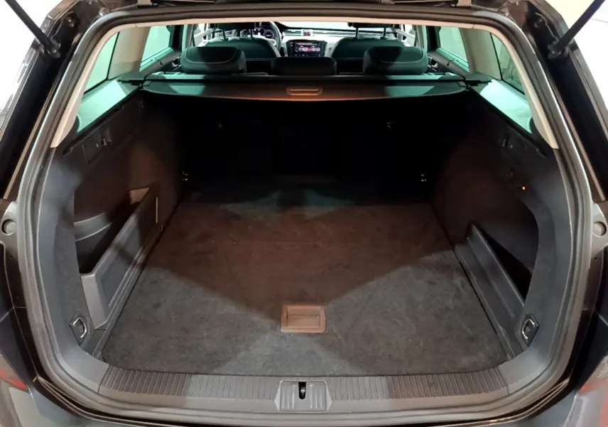 Coffre ouvert vue arrière d'une Volkswagen Passat SW GTE gris foncé, montrant un espace de chargement spacieux et propre.
