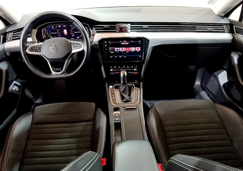 Intérieur avant de la Volkswagen Passat GTE 2022, tableau de bord noir avec écran tactile et volant cuir multifonctions.