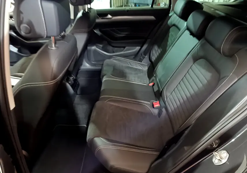 Vue intérieure côté droit sur la banquette arrière en cuir noir avec surpiqûres blanches de la Volkswagen Passat SW GTE hybride rechargeable 2022.