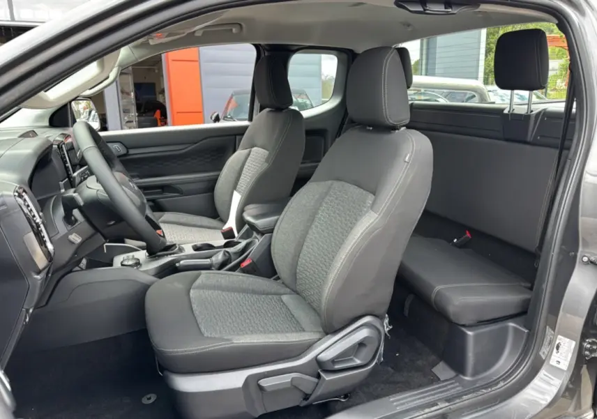 Intérieur du Ford Ranger 2025 gris carbone, vue côté gauche montrant sièges avant et banquette arrière compacte Supercab.