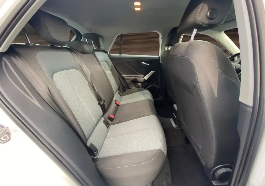 Vue intérieure arrière côté gauche de l'Audi Q2 30 TDI 116 BVM6 2019, avec sièges tissu noir et gris.