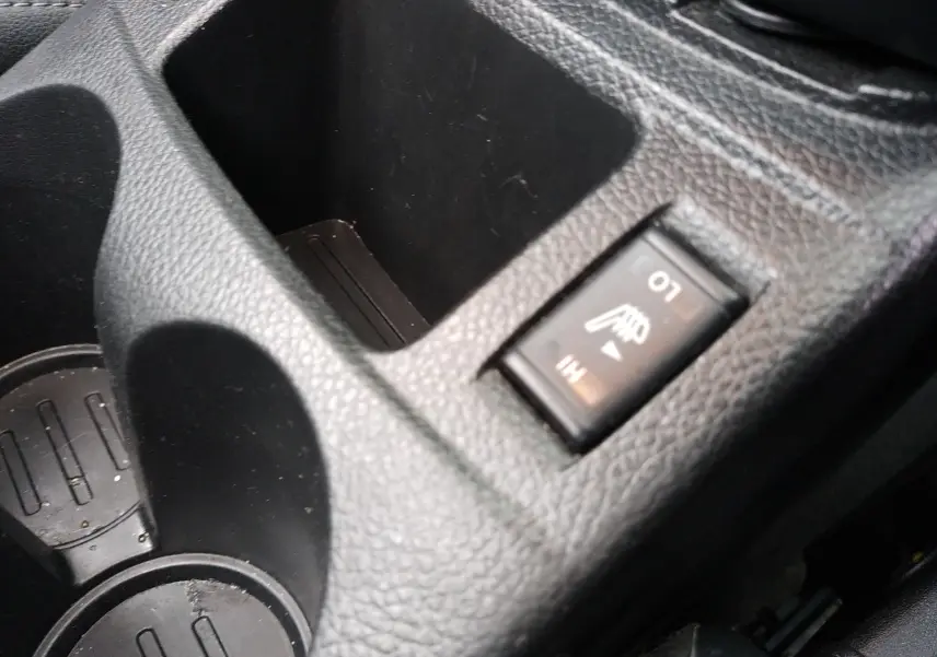 Gros plan sur l'interrupteur de siège chauffant dans la console centrale noire du Nissan Qashqai 2019.