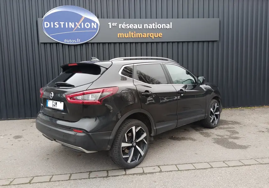 Vue 3/4 arrière droite d'un Nissan Qashqai noir 2019 avec jantes alliage bicolores et vitres teintées.