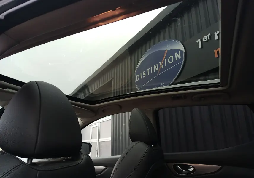 Vue intérieure du Nissan Qashqai Tekna 2019, montrant les sièges avant en cuir noir et le toit panoramique vitré.