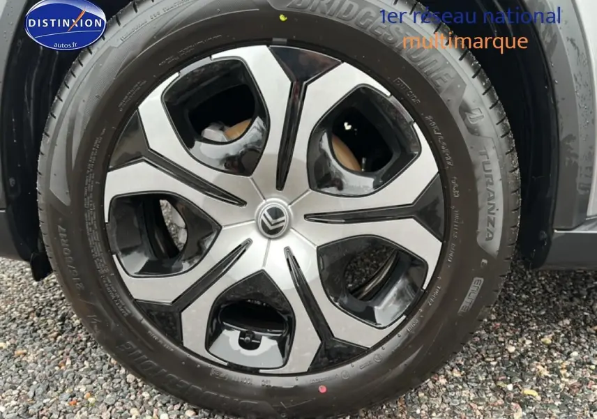 Vue latérale droite d'une Citroën C3 Aircross gris 2025 avec jantes 17 pouces sur sol gravillonné.