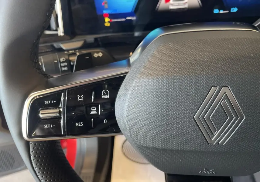 Gros plan sur le volant textile refined gris avec commandes intégrées du Renault Rafale 2025, intérieur moderne et écran digital.