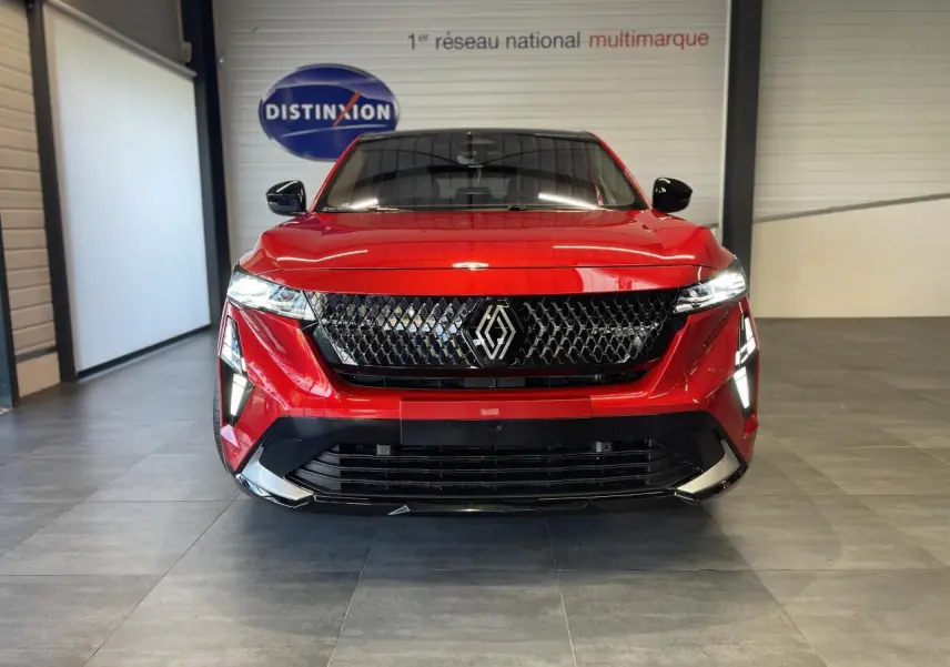 Vue frontale d'une Renault Rafale 2025 rouge avec calandre noire et feux LED allumés dans un showroom.