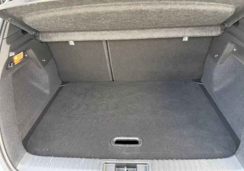 Coffre ouvert du Renault Captur 2025 gris Rafale avec toit noir, vue de l'arrière montrant l'espace de chargement vide.