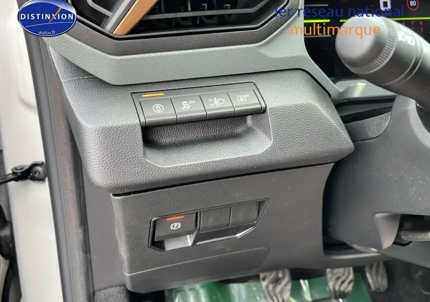 Gros plan sur les commandes sous le tableau de bord côté gauche du Dacia Duster Sandstone 2025.