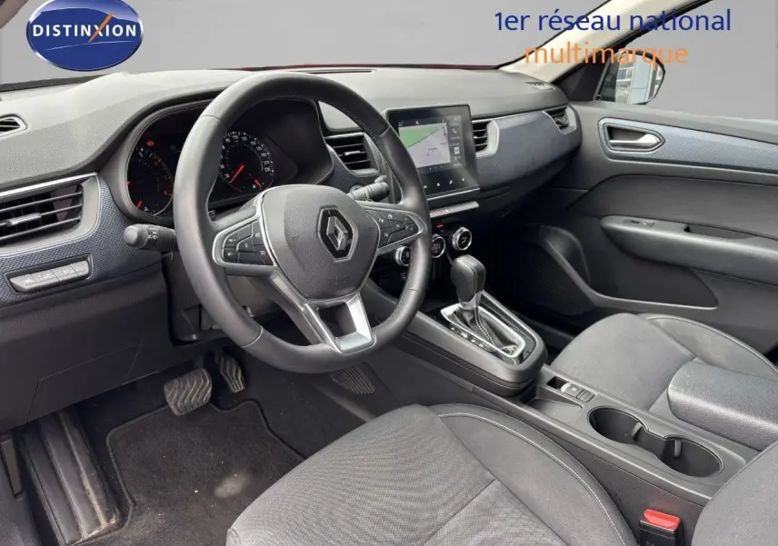 Intérieur du Renault Arkana 2022, vue côté conducteur sur le tableau de bord, volant multifonction et console centrale noire.