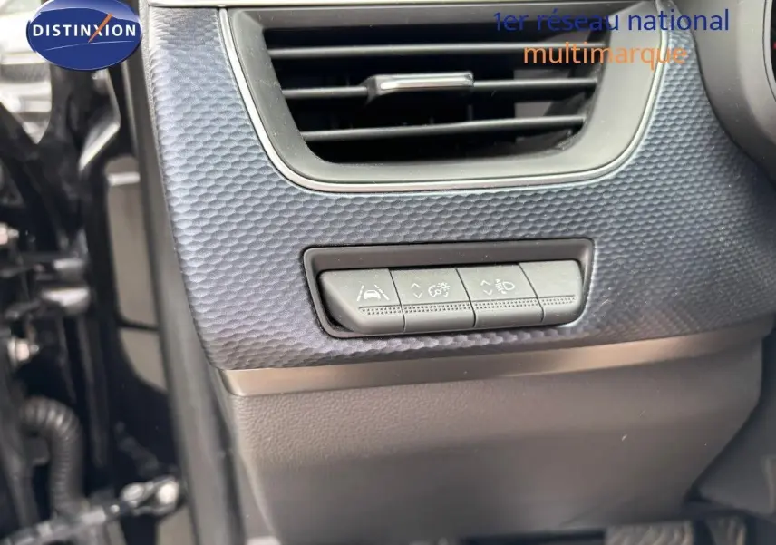 Détail intérieur montrant les commandes d'aide à la conduite sous une sortie d'air sur Renault Arkana noir métal 2022