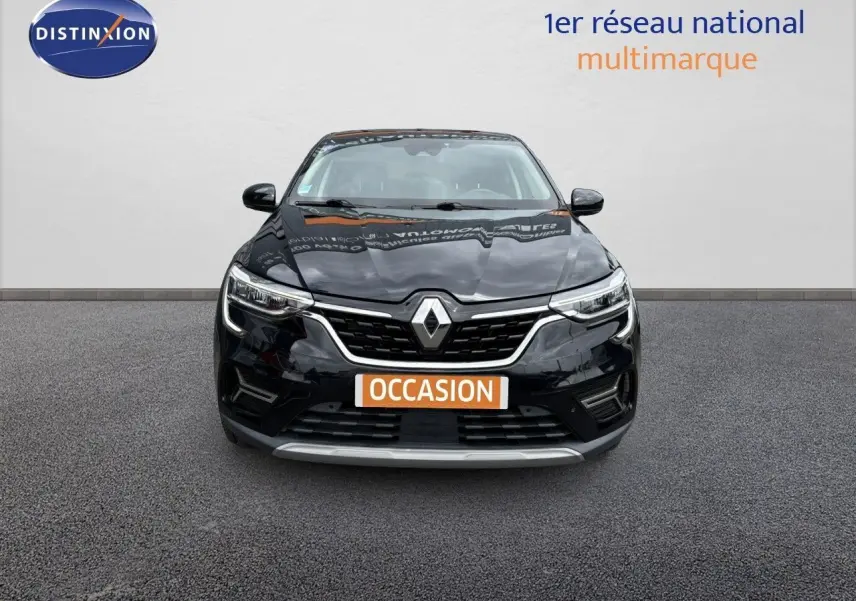 Vue frontale d'un Renault Arkana noir métal 2022 avec calandre chromée et feux LED allumés.