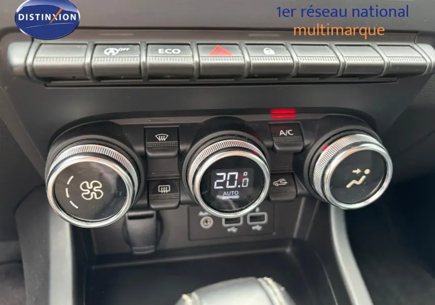 Gros plan sur la console centrale de la Renault Arkana noire, montrant les commandes de climatisation et les boutons fonctionnels.