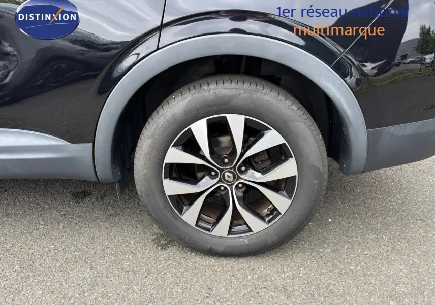 Gros plan sur la roue arrière droite d'un Renault Arkana noir métal avec jante alliage bicolore.