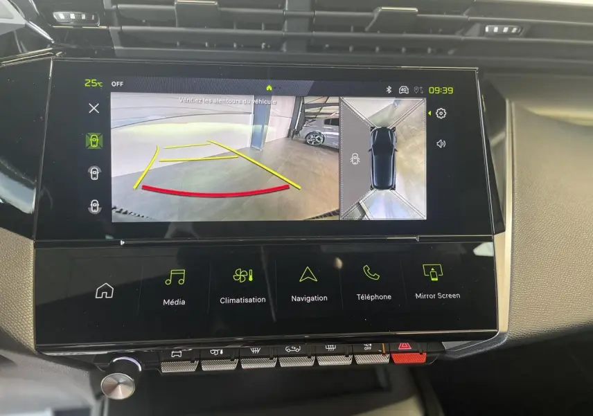 Vue rapprochée de l'écran tactile central de la Peugeot 308 blanche affichant la caméra de recul et la navigation.