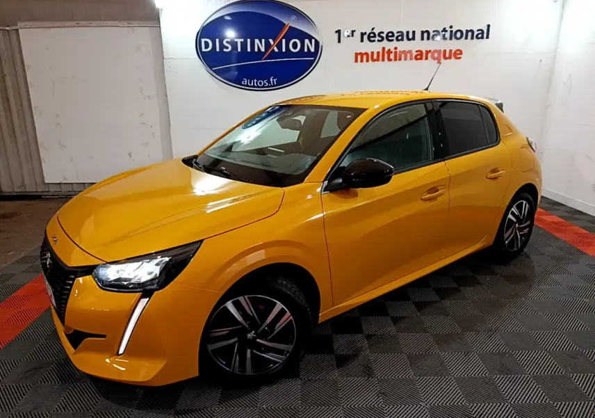 PEUGEOT 208 jaune vue 3/4 avant droit, feux LED allumés, jantes alliage noires, dans un showroom intérieur.