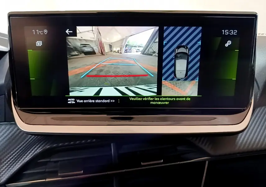 Écran tactile central de la Peugeot 208 affichant la caméra de recul et l'aide au stationnement arrière.