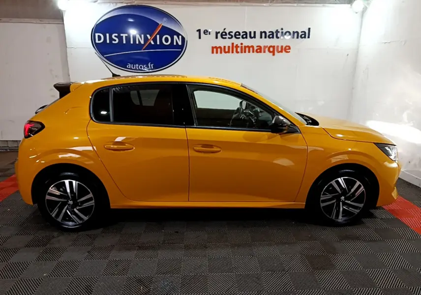 Profil côté gauche d'une Peugeot 208 jaune 2023, finition Allure Pack, dans un showroom lumineux.