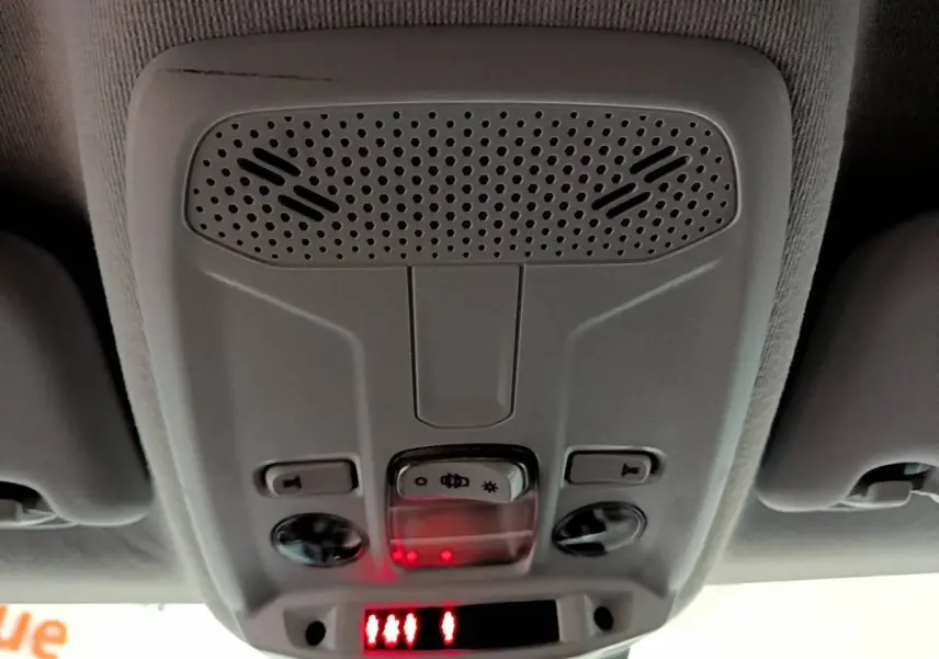 Détail du plafonnier gris clair avec commandes d'éclairage et affichage digital rouge dans une Peugeot 208 jaune.