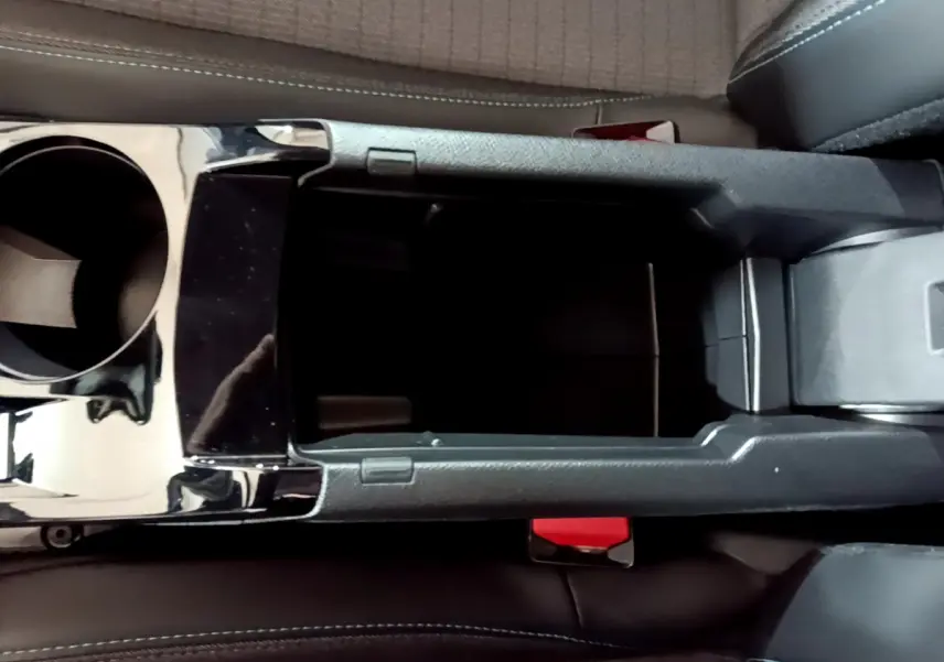 Vue plongeante sur la console centrale noire et les sièges en tissu gris du Peugeot 208 jaune 2023 Allure Pack