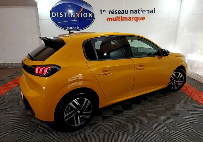 Peugeot 208 jaune vue en 3/4 arrière côté droit, avec feux LED et jantes alliage distinctives.