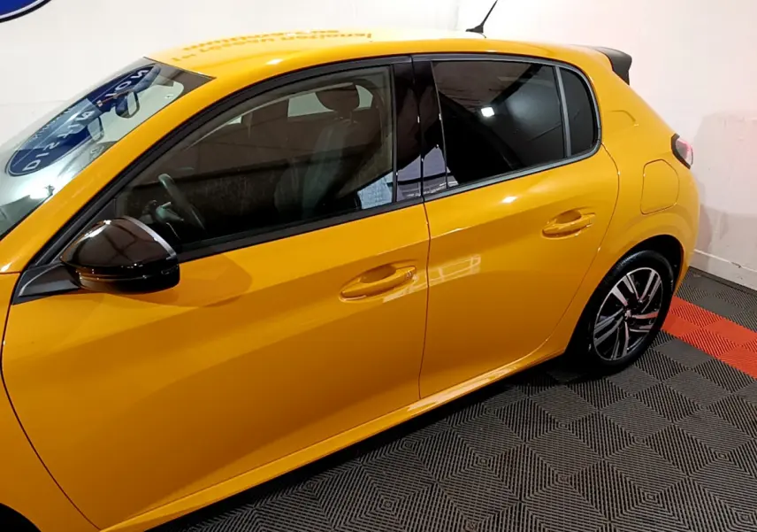 Vue latérale droite d'une Peugeot 208 jaune vif avec rétroviseur noir brillant et jantes alliage design.