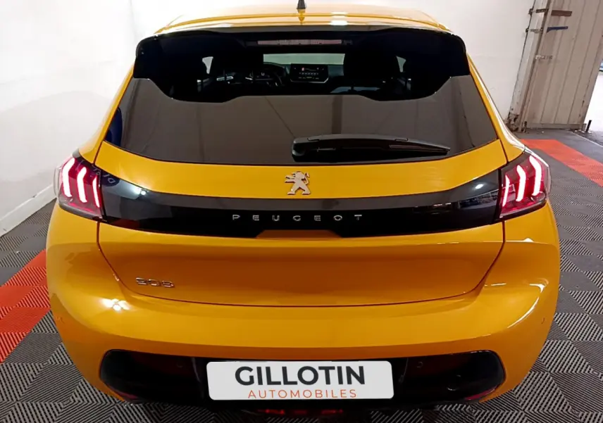 Vue arrière d'une Peugeot 208 jaune 2023 avec feux LED et logo lion sur hayon noir brillant.