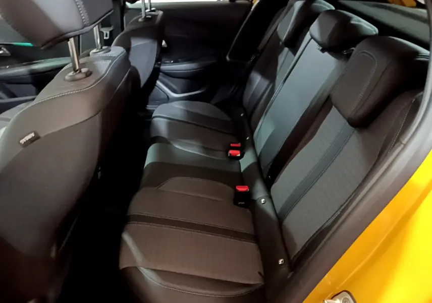 Vue intérieure côté droit sur la banquette arrière noire de la Peugeot 208 jaune 2023 Allure Pack.