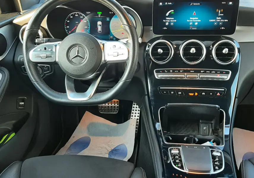 Vue intérieure rapprochée côté conducteur du Mercedes GLC Coupé blanc, sièges sport noirs en cuir et alcantara avec surpiqûres blanches.