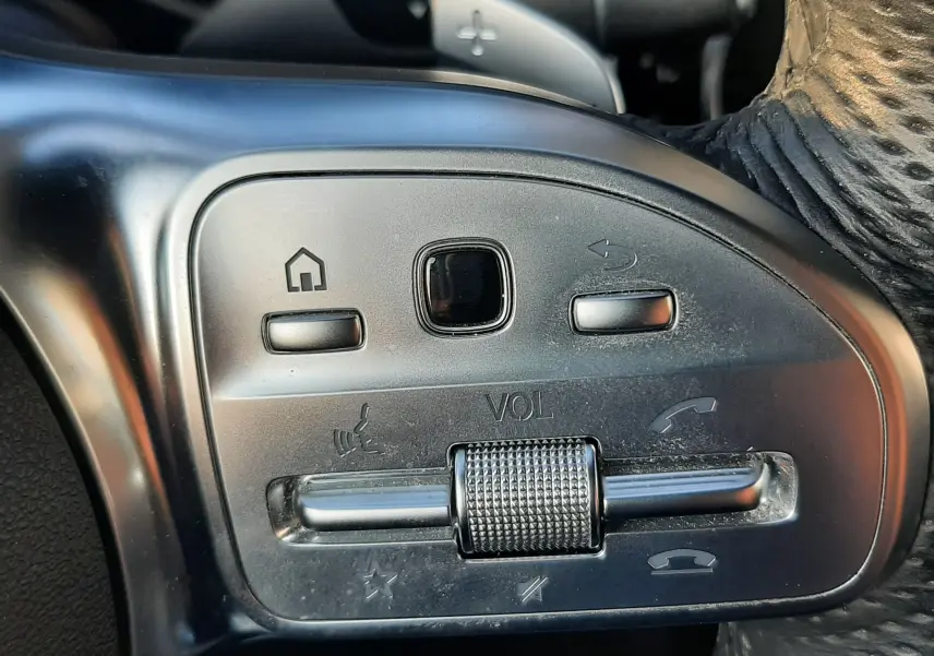 Gros plan sur les commandes de volume et téléphone au volant en cuir noir du Mercedes GLC Coupé blanc 2019 AMG Line.