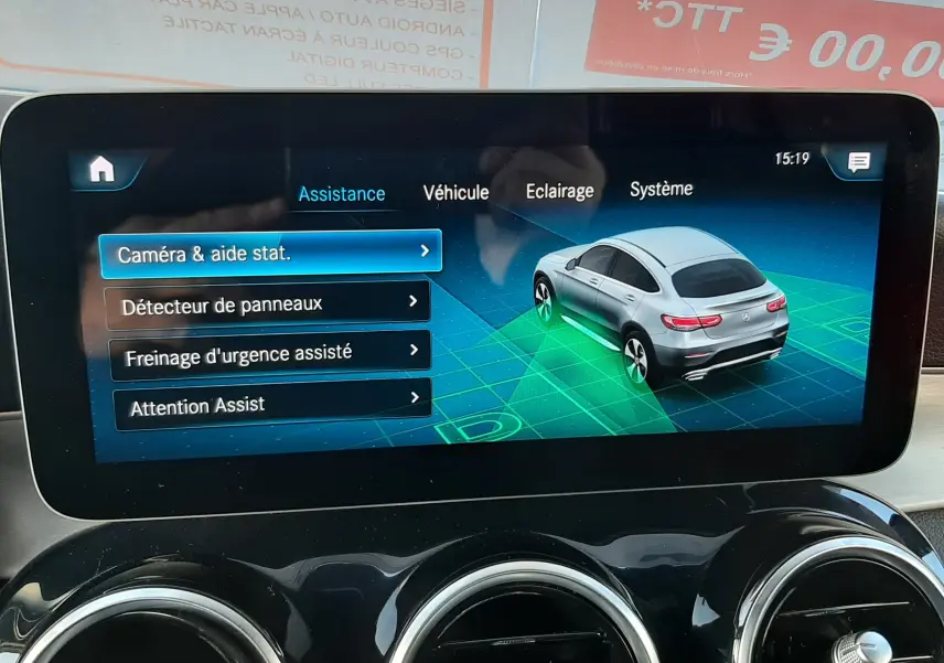 Écran tactile central de la Mercedes GLC Coupé blanc 2019 affichant les applications Smartphone et Navigateur, avec aérateurs ronds chromés.