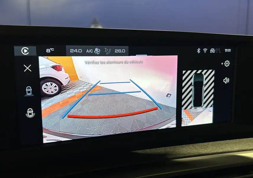 Écran de caméra de recul du Peugeot 3008 noir montrant l’arrière avec lignes de guidage colorées en bleu et rouge.