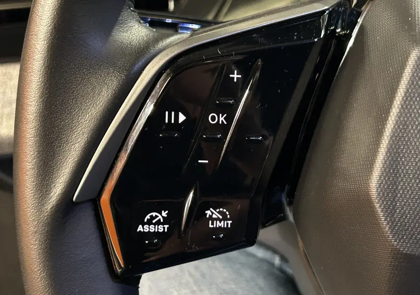 Gros plan sur les commandes noires du volant côté gauche du Peugeot 3008 III Hybrid 145 e-DSC6 Allure 2025.