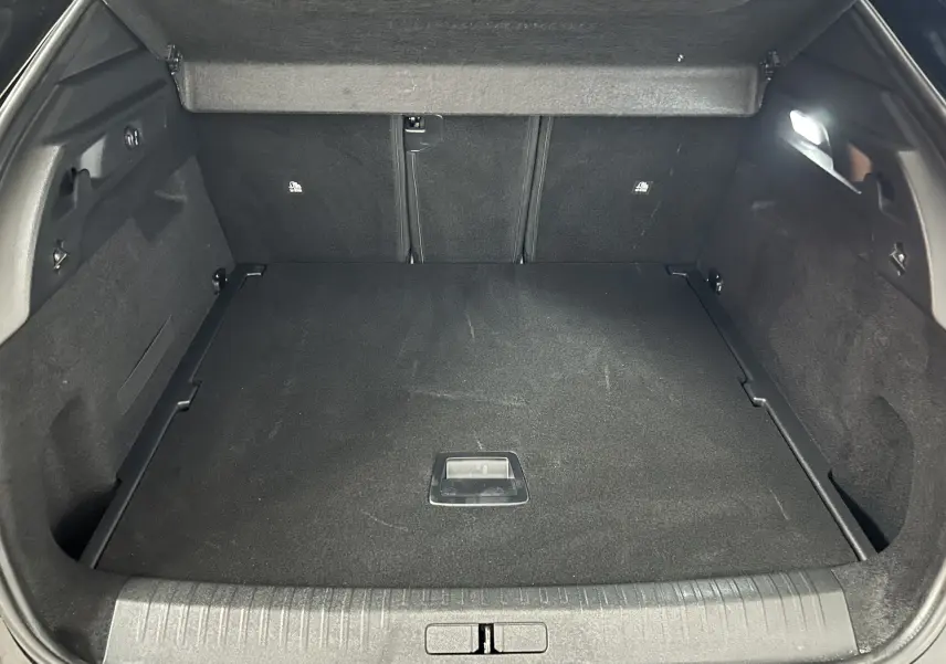 Coffre ouvert vu de face du Peugeot 3008 noir, montrant un espace de chargement propre et bien éclairé.
