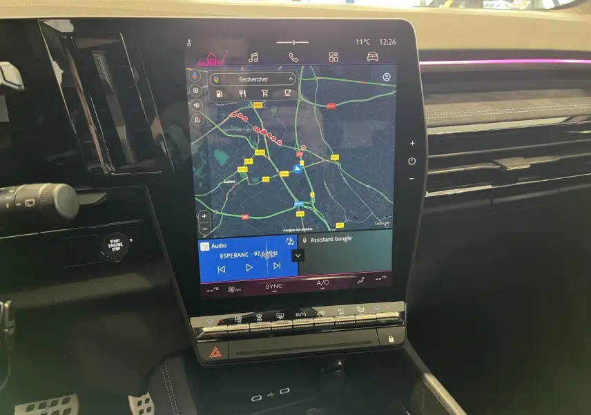 Vue rapprochée de l’écran tactile central du Renault Austral 2025 affichant la navigation et la radio, intérieur noir.