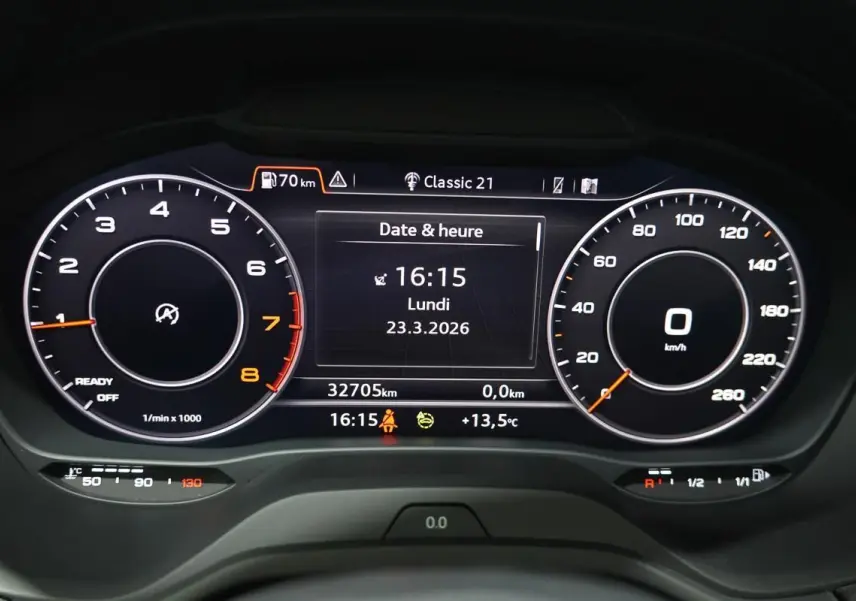 Tableau de bord numérique de l'Audi Q2 TFSI 110, affichage date et heure, compte-tours et vitesse à 0 km/h.