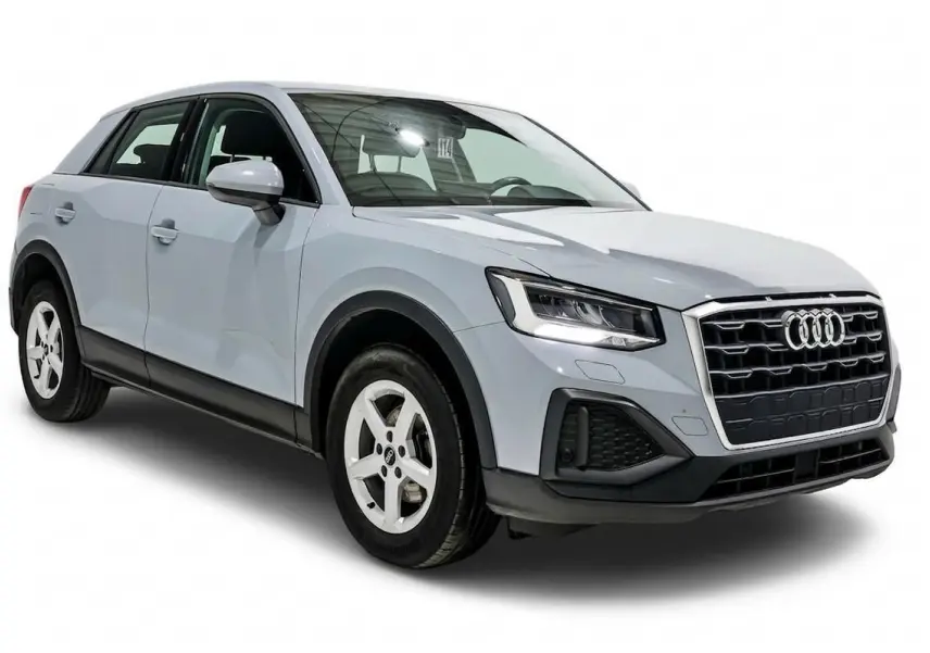 Audi Q2 gris vue 3/4 avant droit, avec calandre distinctive et phares LED allumés sur fond blanc.