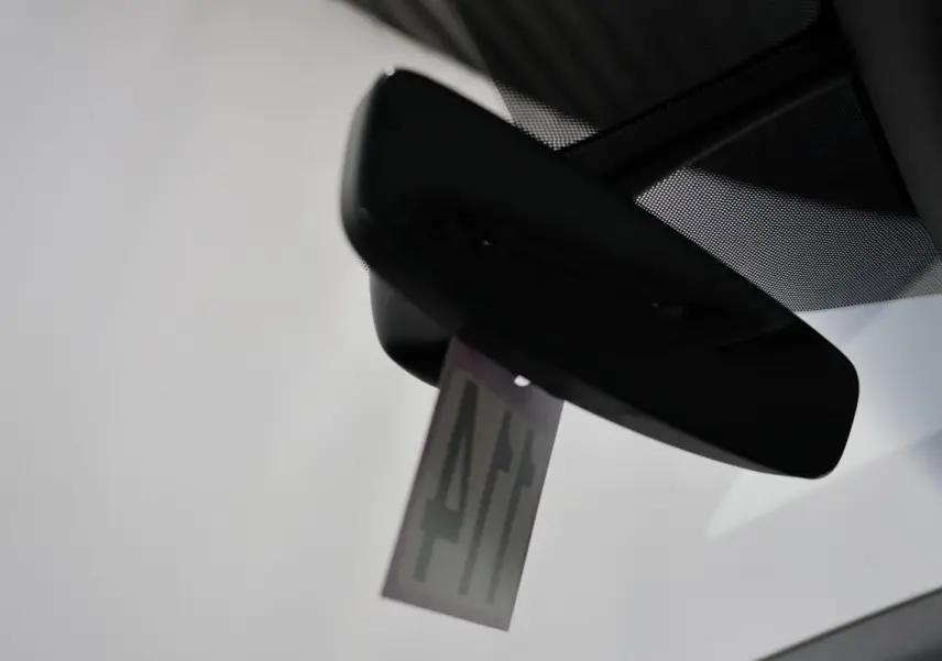 Vue intérieure centrée sur le rétroviseur intérieur d'un Audi Q2 gris 2023 avec pare-brise clair.